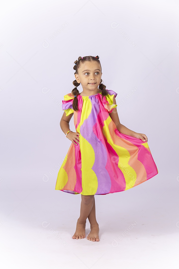 Criança vestida com um lindo vestido colorido sobre um fundo isolado branco.
