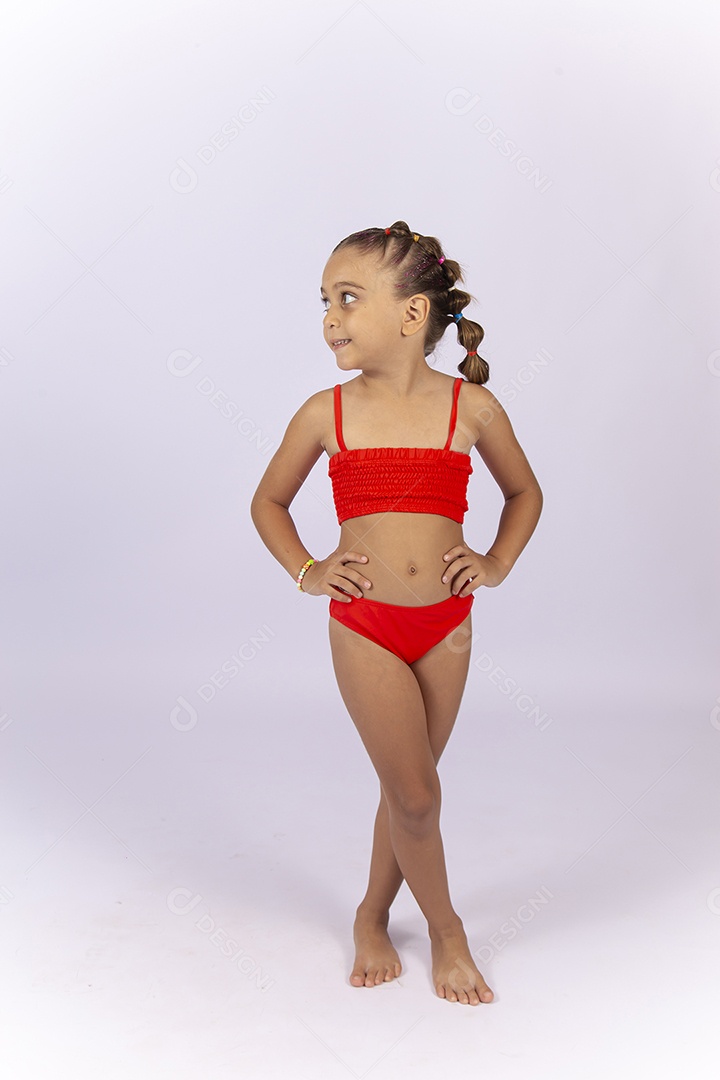 Criança vestida de biquini laranja sobre um fundo isolado branco.