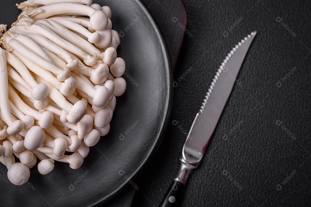 Pequenos cogumelos de faia comestíveis brancos com sal e especiarias sobre um fundo liso. Ingredientes para pratos asiáticos
