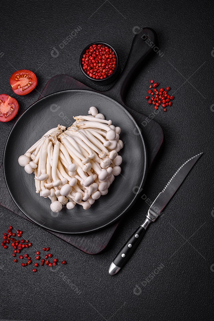 Pequenos cogumelos de faia comestíveis brancos com sal e especiarias sobre um fundo liso. Ingredientes para pratos asiáticos