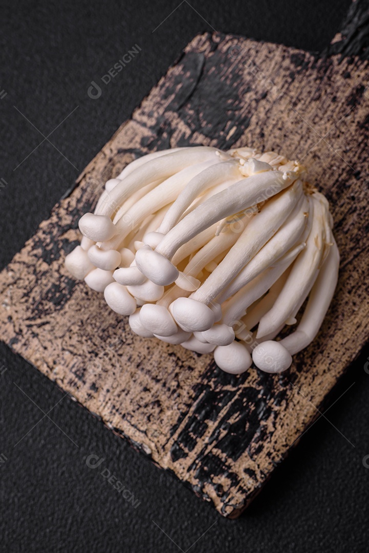 Pequenos cogumelos de faia comestíveis brancos com sal e especiarias sobre um fundo liso. Ingredientes para pratos asiáticos