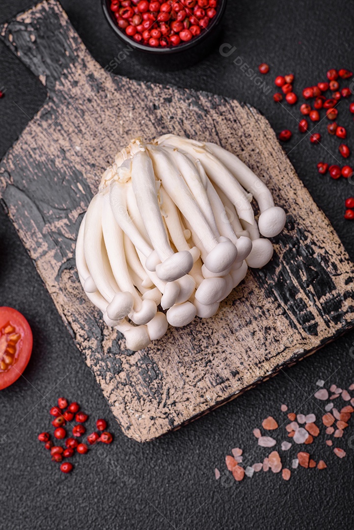 Pequenos cogumelos de faia comestíveis brancos com sal e especiarias sobre um fundo liso. Ingredientes para pratos asiáticos