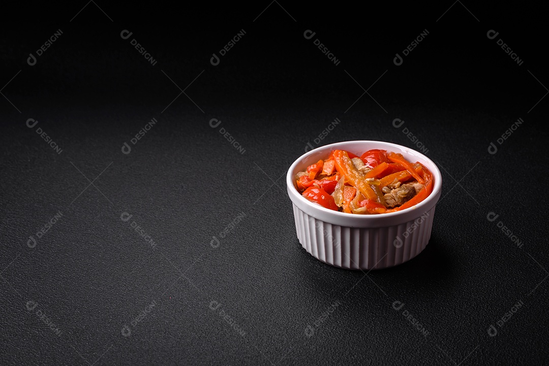 Delicioso ensopado fresco com frango ou peru com fatias de pimentão e cenoura com sal e especiarias sobre um fundo escuro de concreto
