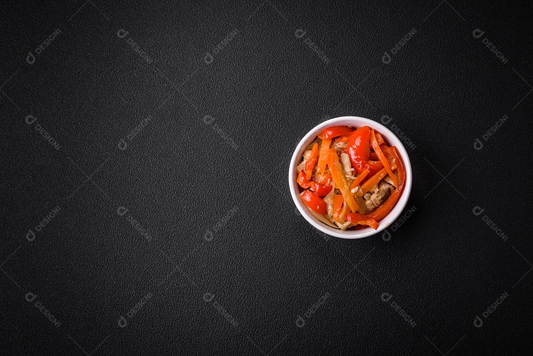 Delicioso ensopado fresco com frango ou peru com fatias de pimentão e cenoura com sal e especiarias sobre um fundo escuro de concreto