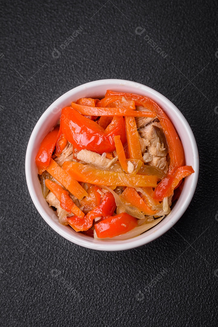 Delicioso ensopado fresco com frango ou peru com fatias de pimentão e cenoura com sal e especiarias sobre um fundo escuro de concreto