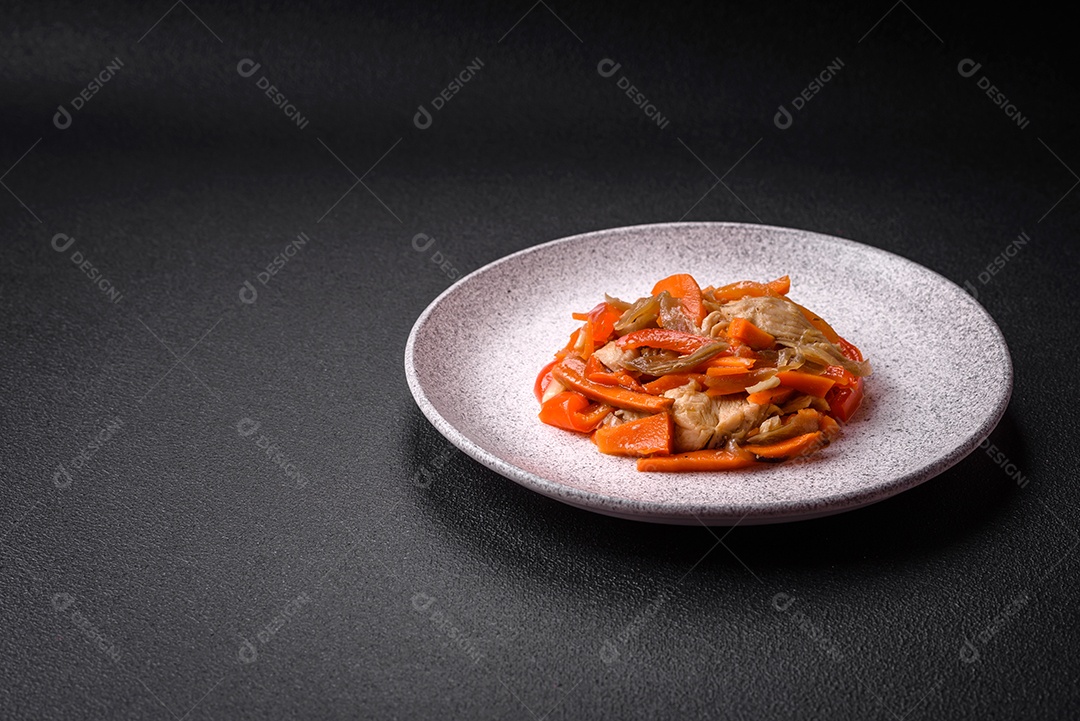 Delicioso ensopado fresco com frango ou peru com fatias de pimentão e cenoura com sal e especiarias sobre um fundo escuro de concreto