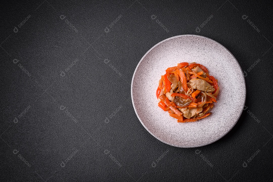 Delicioso ensopado fresco com frango ou peru com fatias de pimentão e cenoura com sal e especiarias sobre um fundo escuro de concreto
