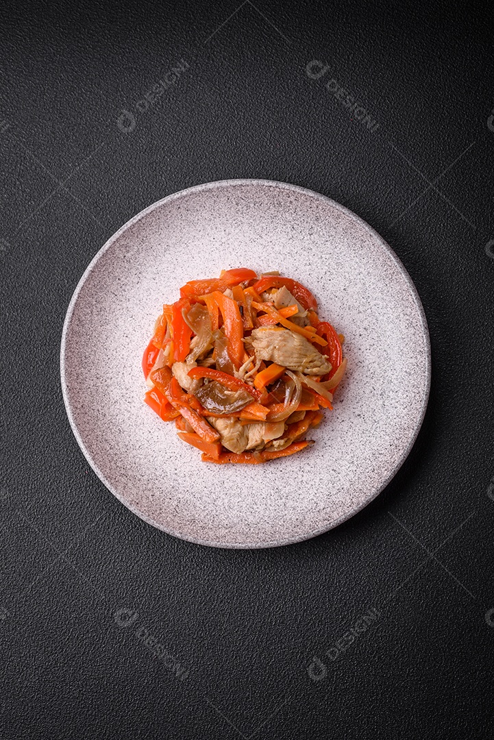 Delicioso ensopado fresco com frango ou peru com fatias de pimentão e cenoura com sal e especiarias sobre um fundo escuro de concreto