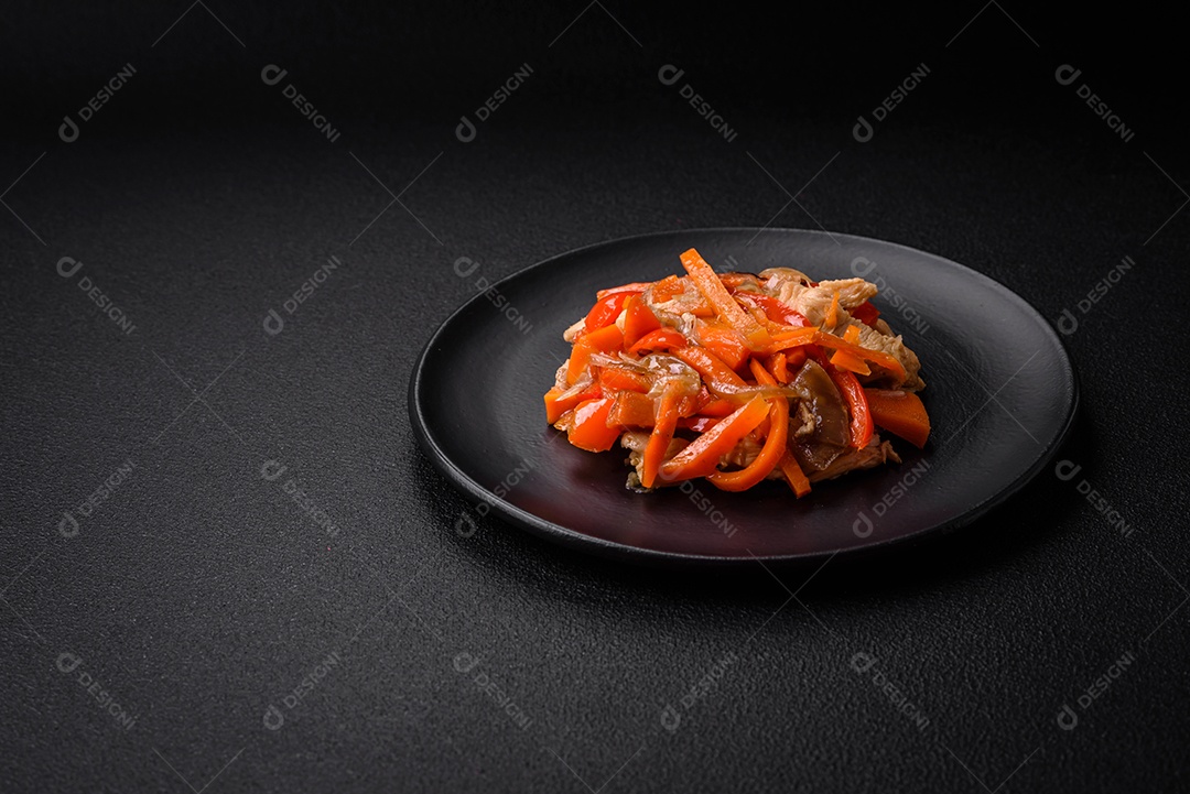 Delicioso ensopado fresco com frango ou peru com fatias de pimentão e cenoura com sal e especiarias sobre um fundo escuro de concreto