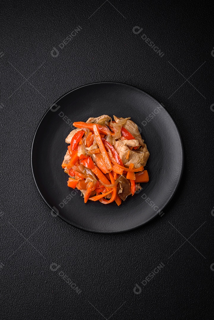 Delicioso ensopado fresco com frango ou peru com fatias de pimentão e cenoura com sal e especiarias sobre um fundo escuro de concreto