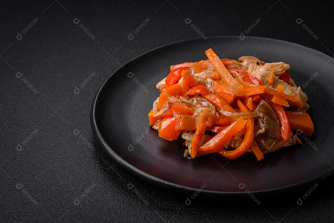 Delicioso ensopado fresco com frango ou peru com fatias de pimentão e cenoura com sal e especiarias sobre um fundo escuro de concreto