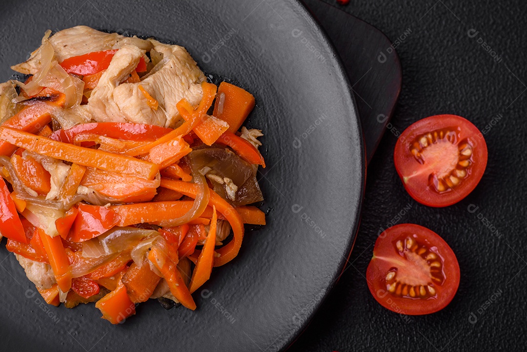 Delicioso ensopado fresco com frango ou peru com fatias de pimentão e cenoura com sal e especiarias sobre um fundo escuro de concreto