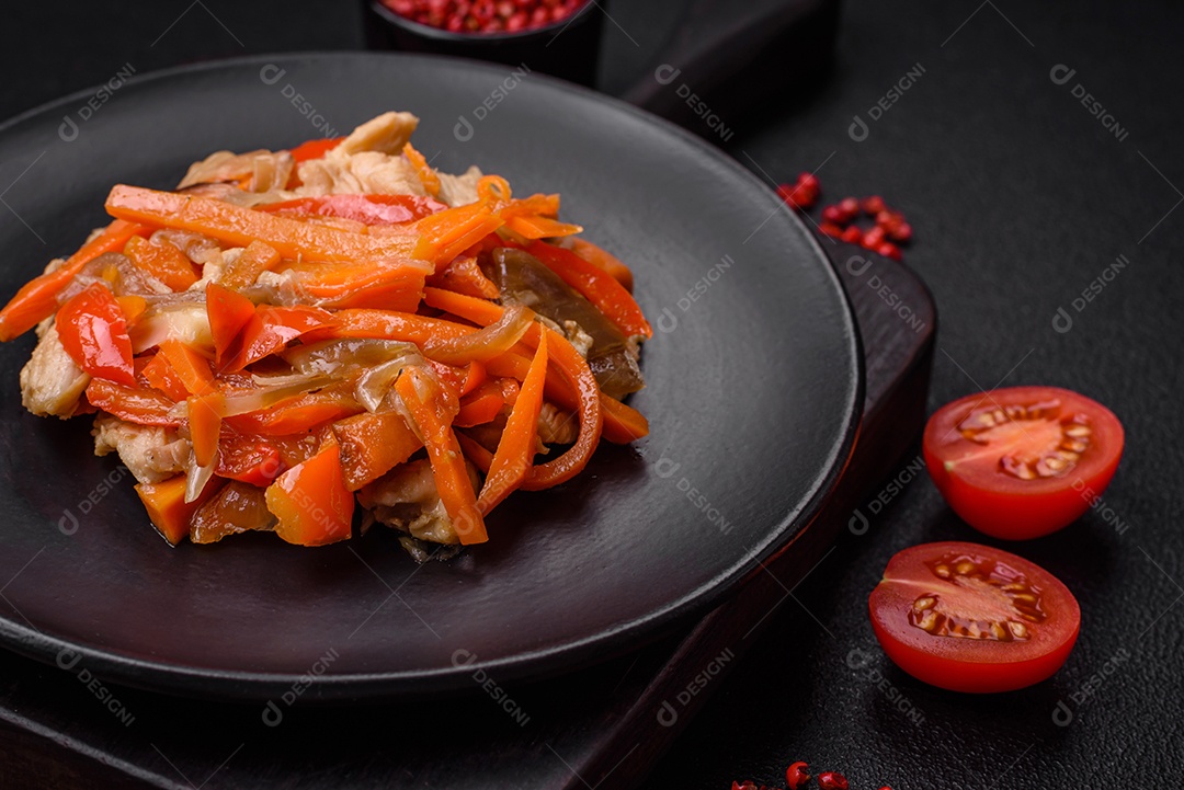 Delicioso ensopado fresco com frango ou peru com fatias de pimentão e cenoura com sal e especiarias sobre um fundo escuro de concreto