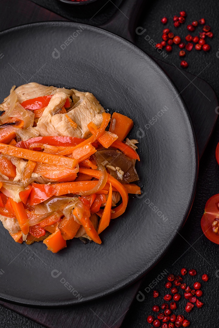 Delicioso ensopado fresco com frango ou peru com fatias de pimentão e cenoura com sal e especiarias sobre um fundo escuro de concreto