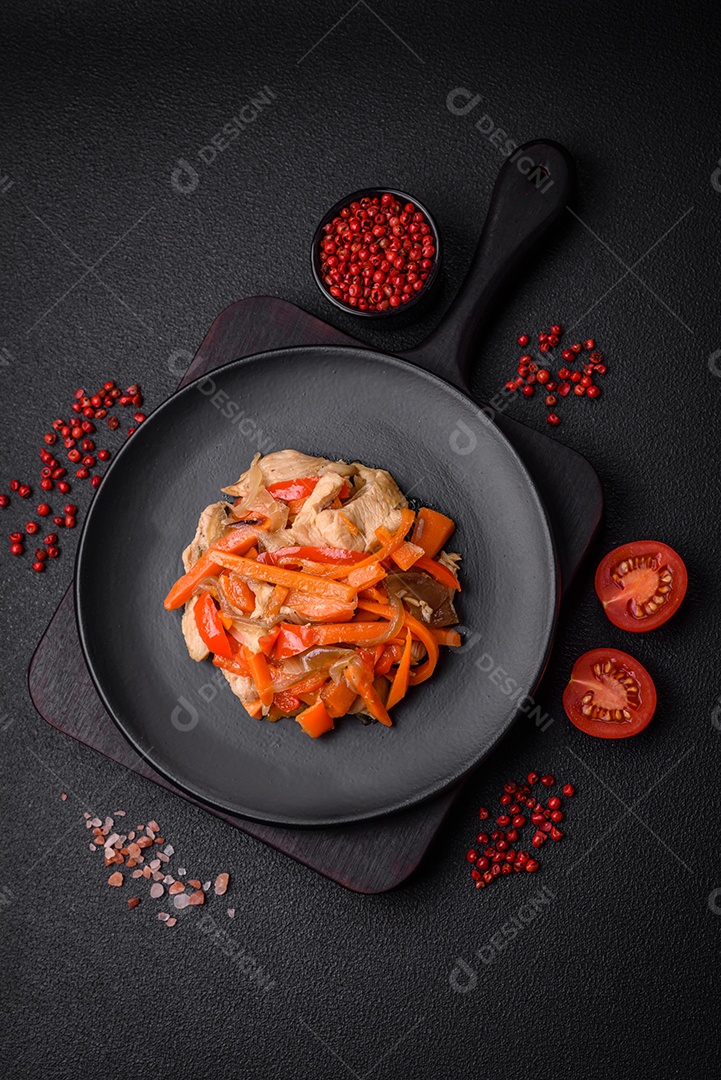 Delicioso ensopado fresco com frango ou peru com fatias de pimentão e cenoura com sal e especiarias sobre um fundo escuro de concreto