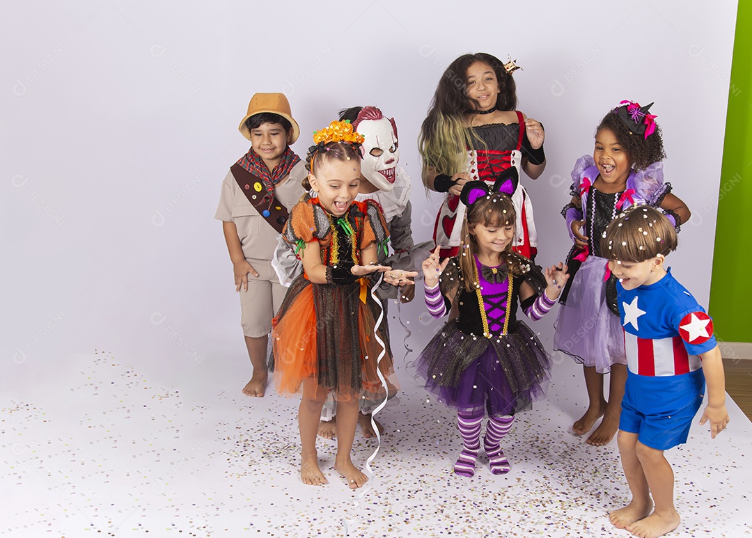 Crianças fantasiadas brincando com confetes.
