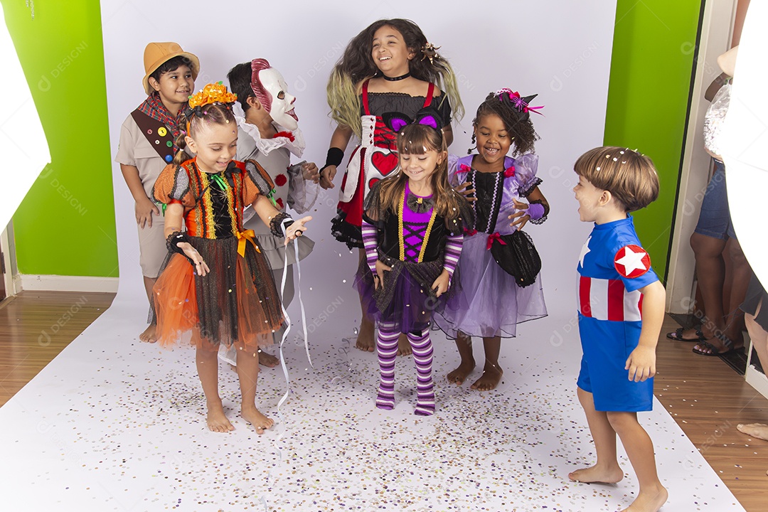 Crianças fantasiadas brincando com confetes.