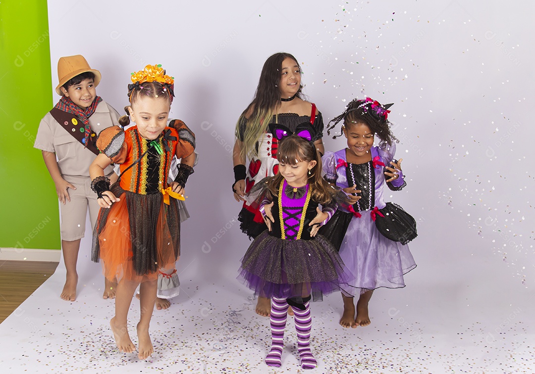 Crianças fantasiadas brincando com confetes.