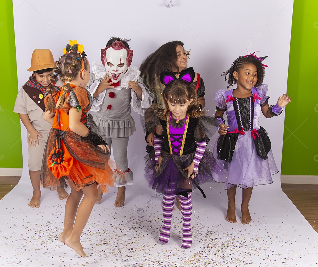 Crianças fantasiadas brincando com confetes.