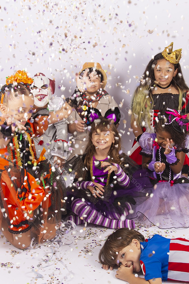 Cianças fantasiadas brincando com confetes.