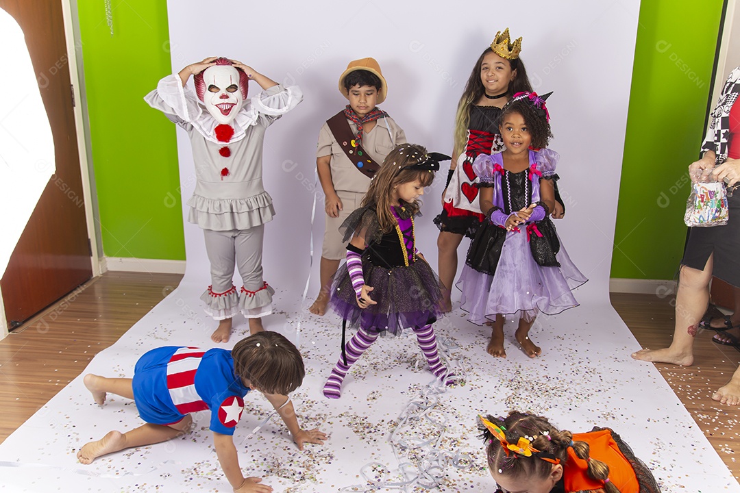 Crianças fantasiadas de Halloween brincando com confetes.