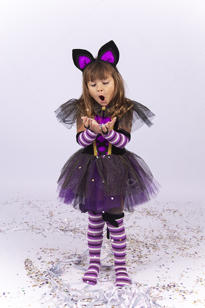 Linda menina fantasiada de bruxa sobre um fundo isolado branco.