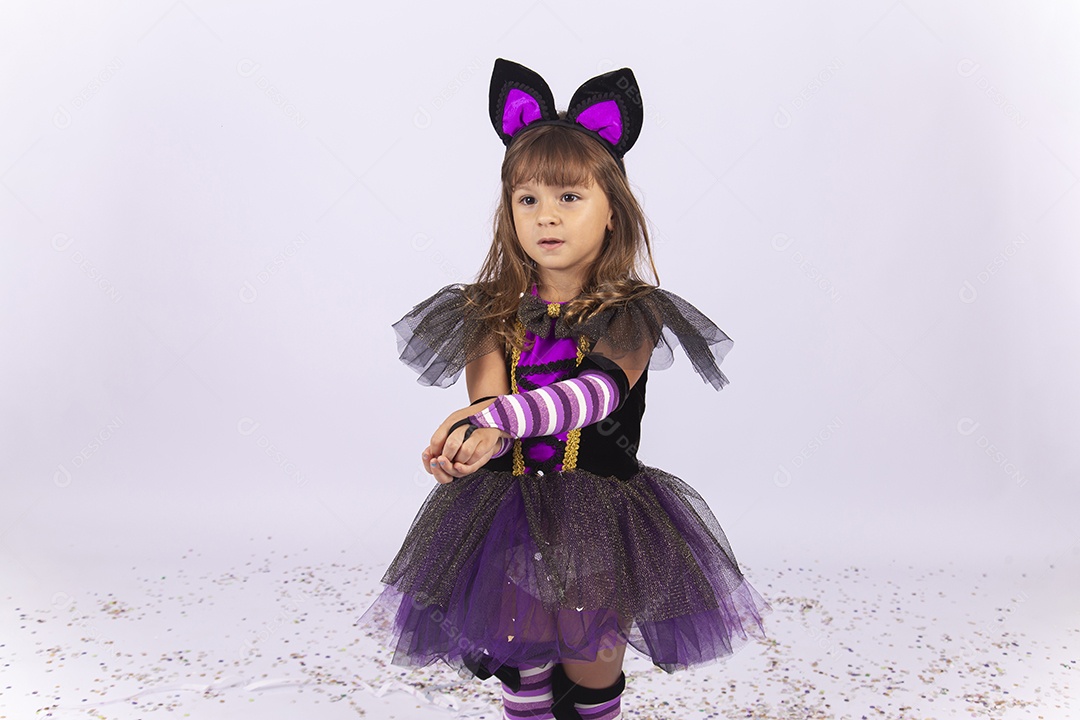 Linda menina fantasiada de bruxa sobre um fundo isolado branco.