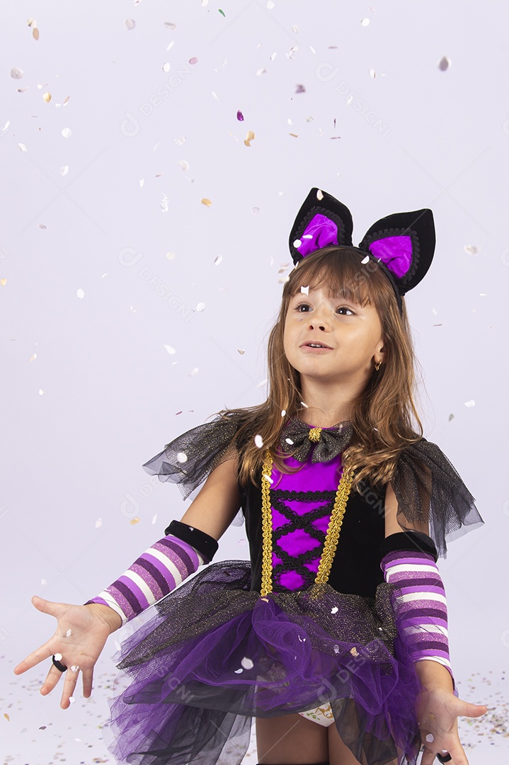 Linda menina fantasiada de bruxa sobre um fundo isolado branco.