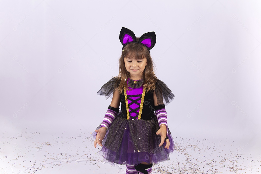 Linda menina fantasiada de bruxa sobre um fundo isolado branco.