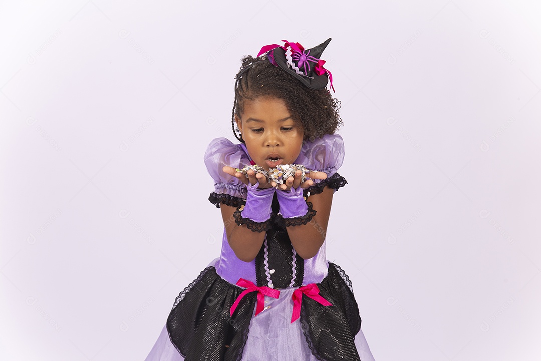 Linda menina fantasiada para o Halloween brincando com confetes.