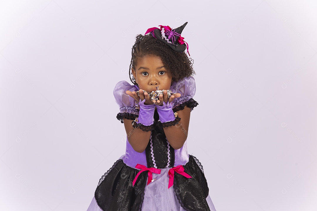 Linda menina fantasiada para o Halloween brincando com confetes.