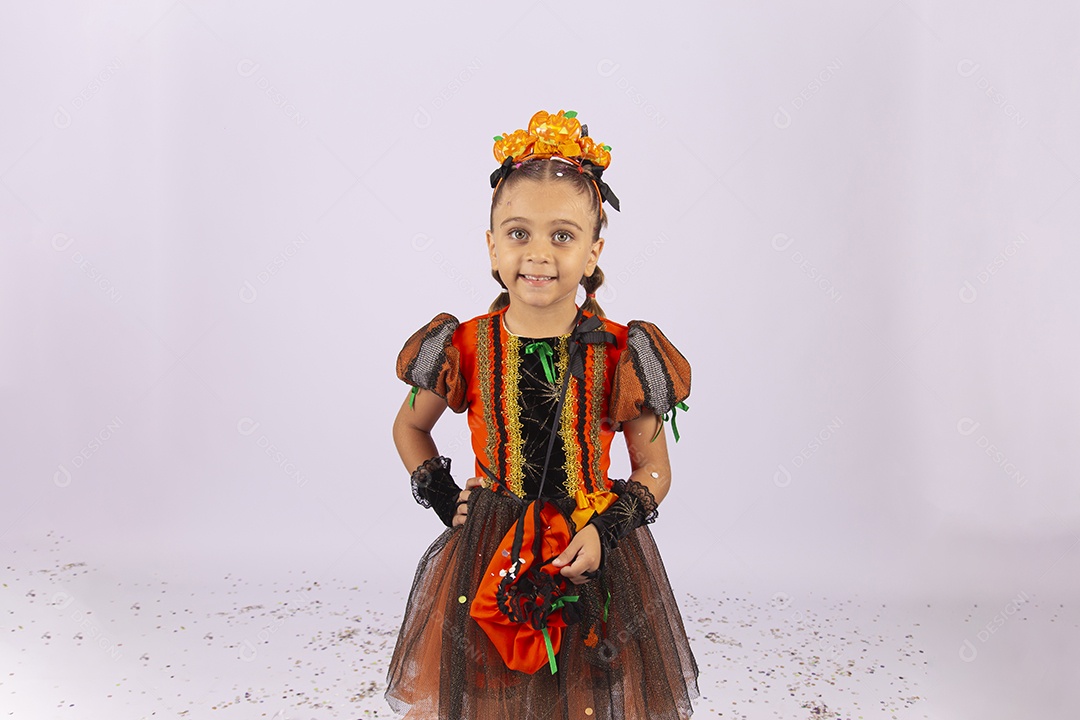 Linda menina fantasiada de bruxa sobre um fundo isolado branco.