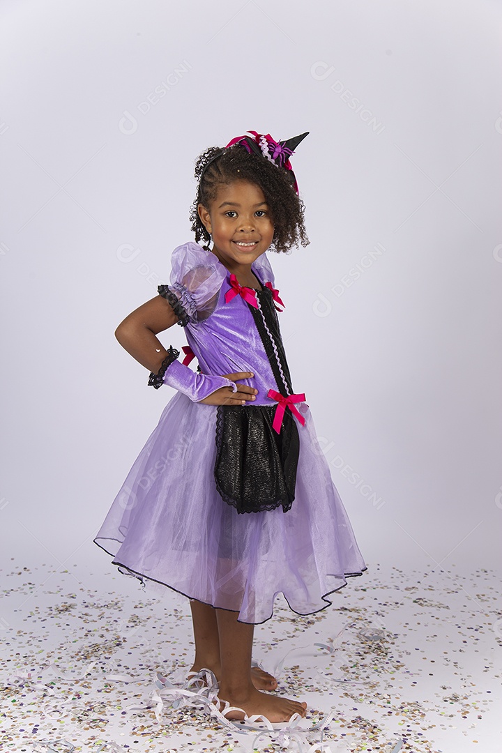 Linda menina fantasiada de bruxa sobre um fundo isolado branco.