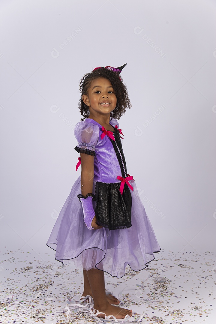 Linda menina fantasiada de bruxa sobre um fundo isolado branco.
