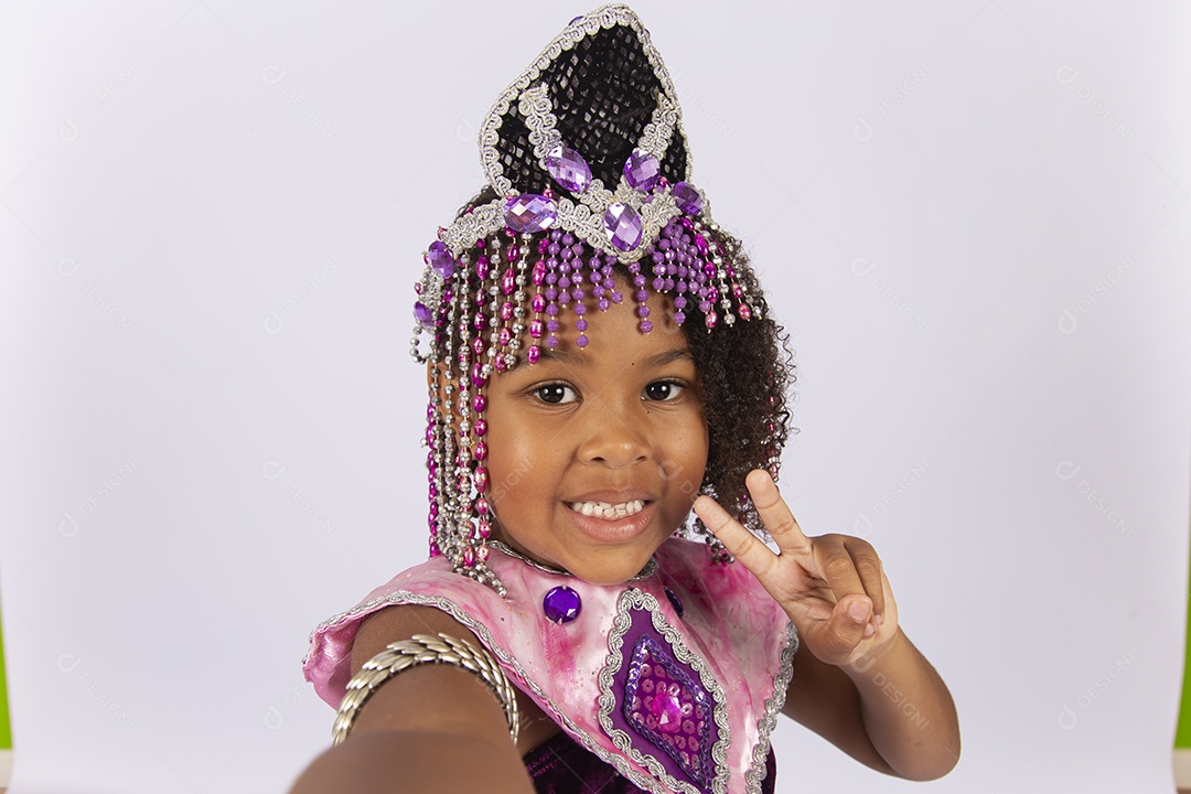 Linda menina de cabelo cacheado fantasiada sobre um fundo isolado branco.