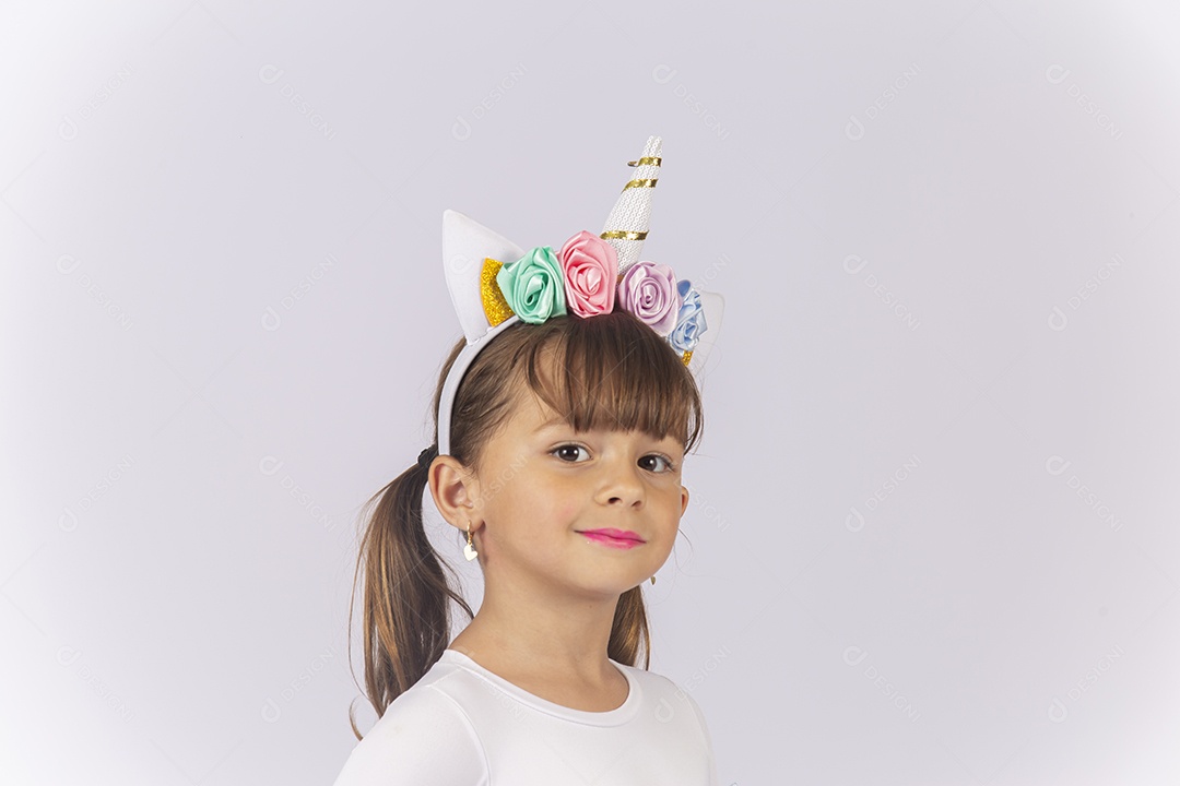 Linda garotinha com acessório de flores na cabeça sobre um fundo isolado branco.