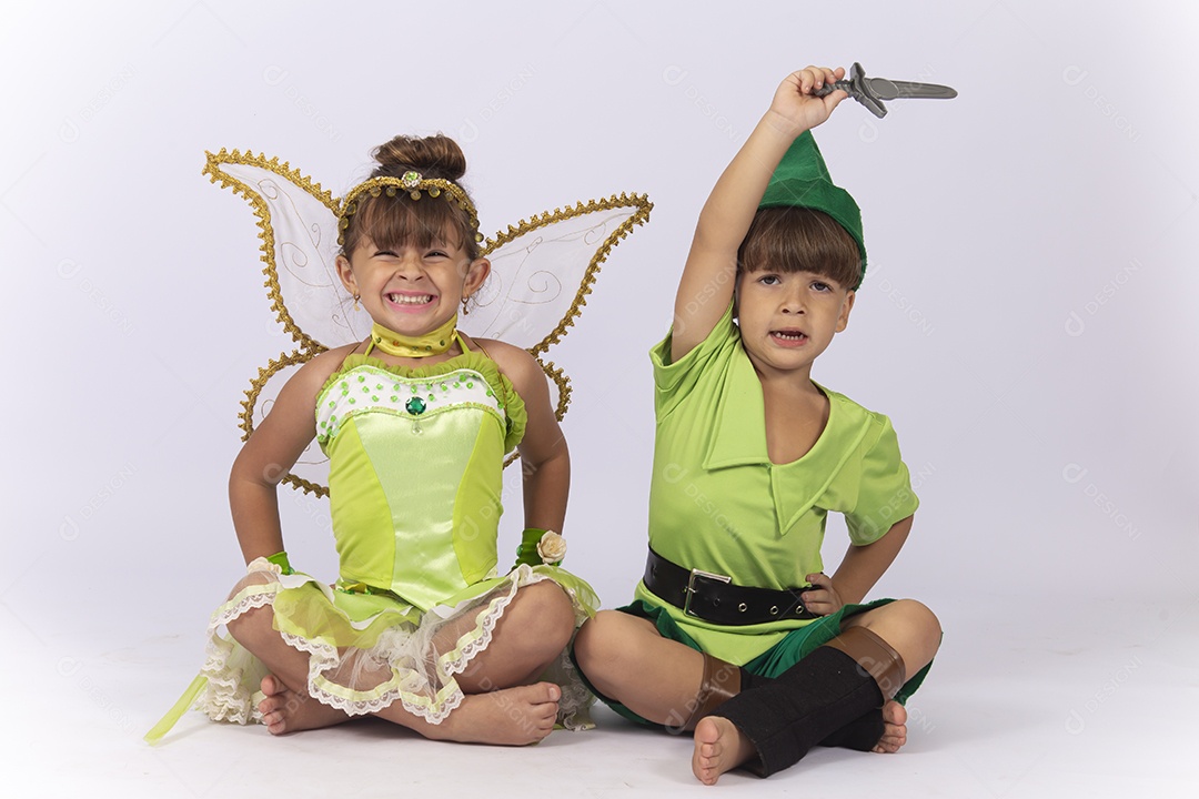Crianças sentadas no chão fantasiadas sobre um fundo isolado branco.
