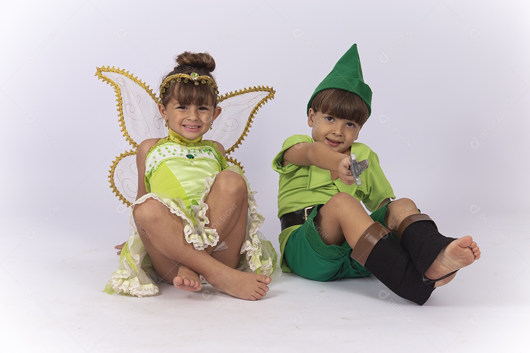 Crianças sentadas no chão fantasiadas sobre um fundo isolado branco.