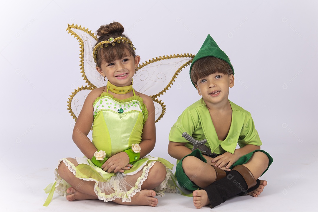 Crianças sentadas no chão fantasiadas sobre um fundo isolado branco.