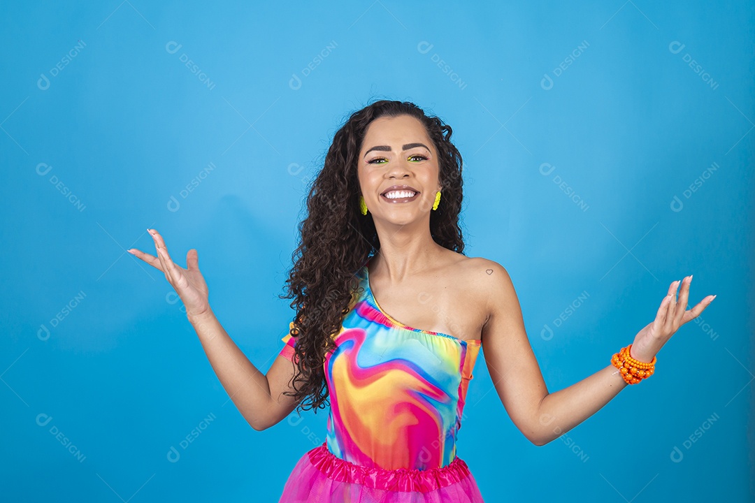 Mulher de cabelo cacheado com fantasia de carnaval sobre fundo isolado azul.