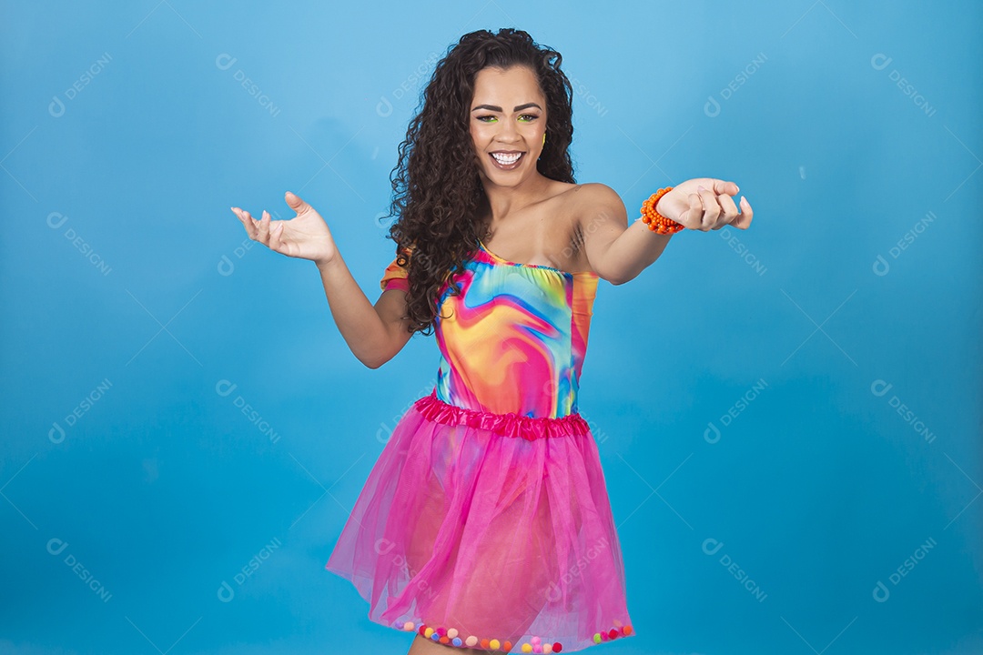 Mulher de cabelo cacheado com fantasia de carnaval sobre fundo isolado azul.