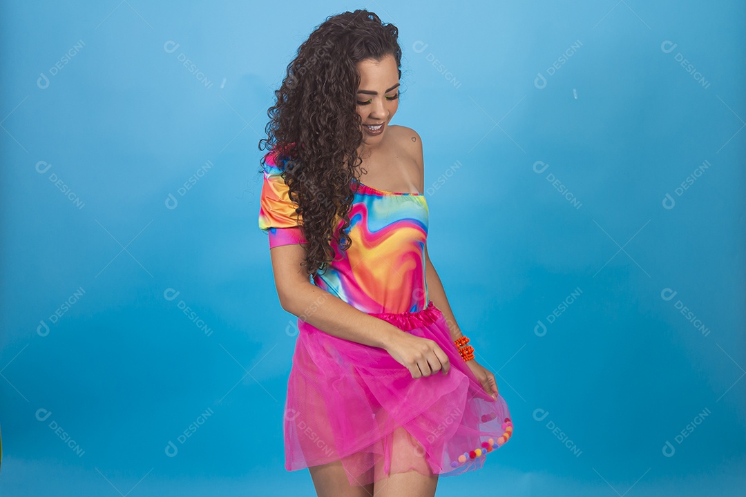 Mulher de cabelo cacheado com fantasia de carnaval sobre fundo isolado azul.