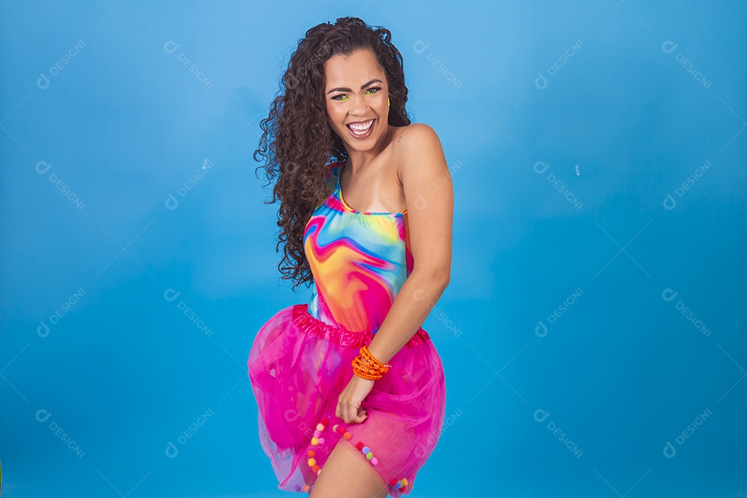 Mulher de cabelo cacheado com fantasia de carnaval sobre fundo isolado azul.