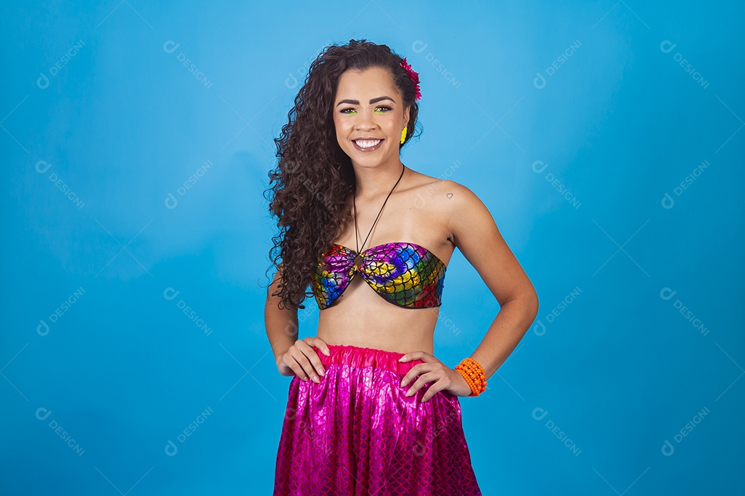 Mulher de cabelo cacheado com fantasia de carnaval sobre fundo isolado azul.