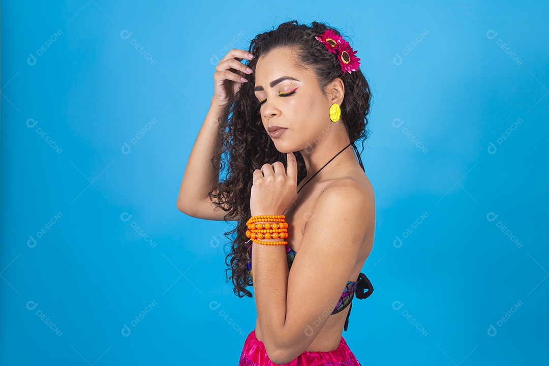 Linda mulher de cabelo cacheado sobre fundo isolado azul.