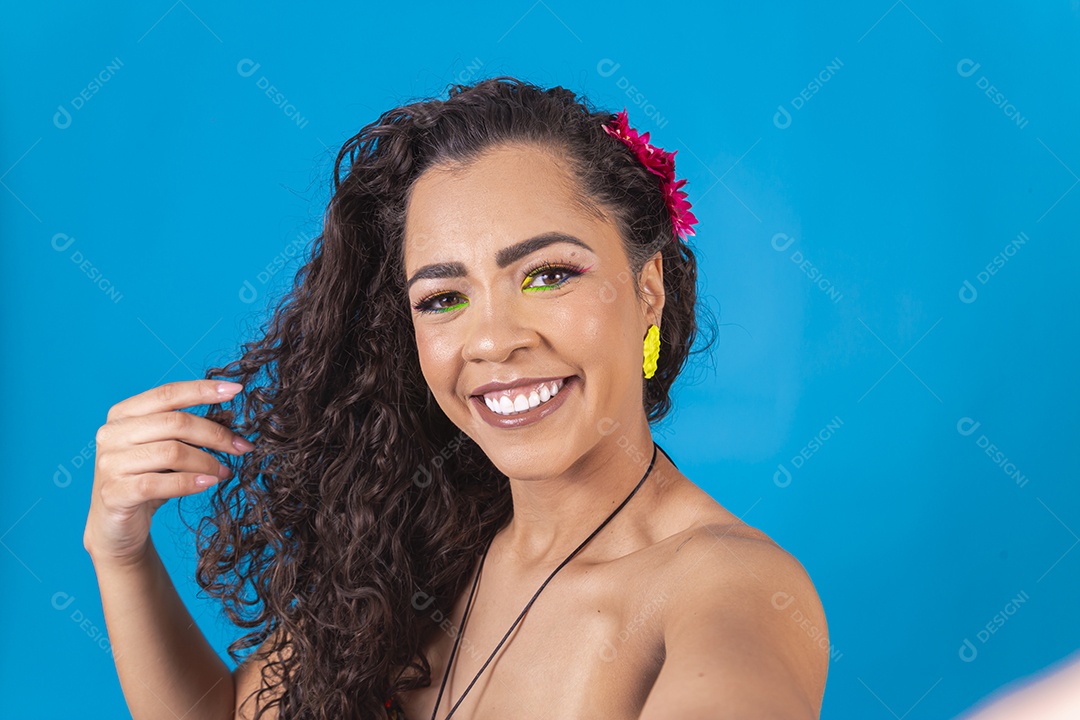 Linda mulher de cabelo cacheado sobre fundo isolado azul.