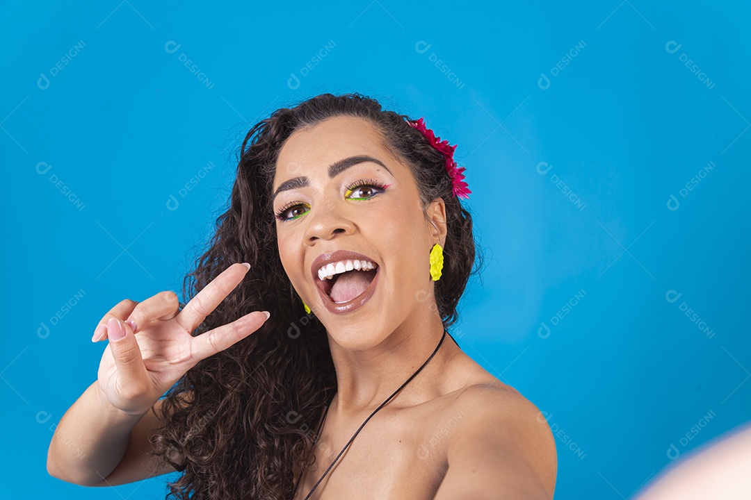 Linda mulher de cabelo cacheado sobre fundo isolado azul.