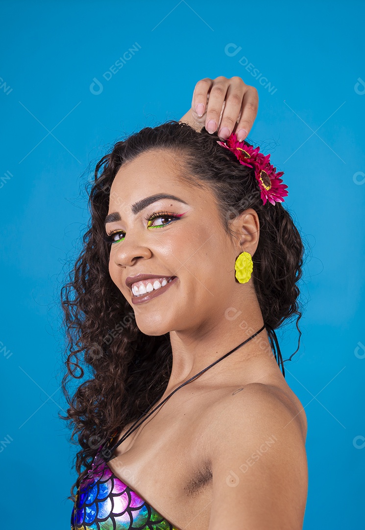 Linda mulher de cabelo cacheado sobre fundo isolado azul.