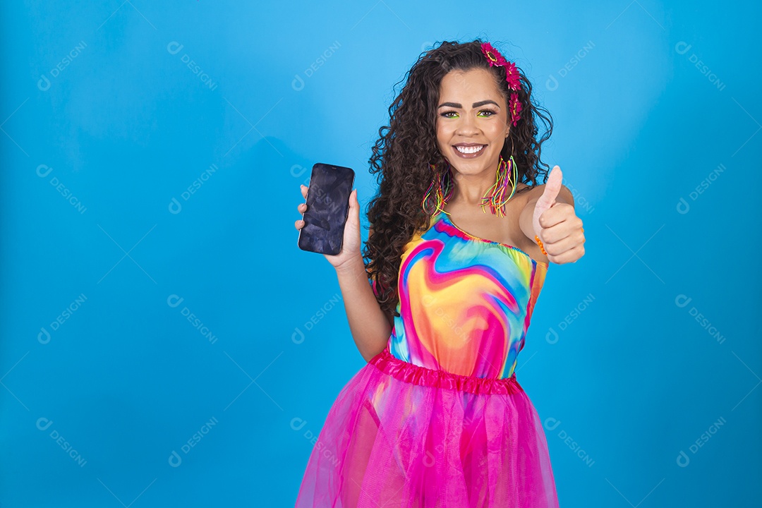 Mulher de cabelo cacheado com fantasia de carnaval segurando celular.