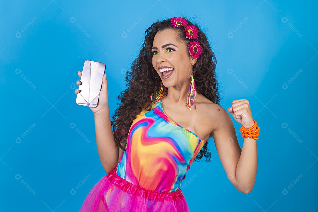 Mulher de cabelo cacheado com fantasia de carnaval segurando celular.